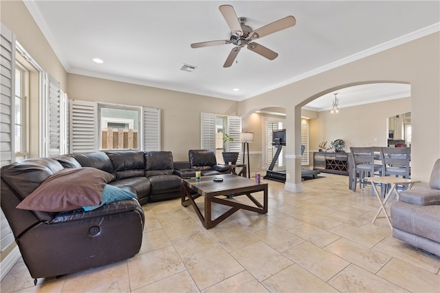 living room featuring ceiling fan, plenty of natural light, and crown molding