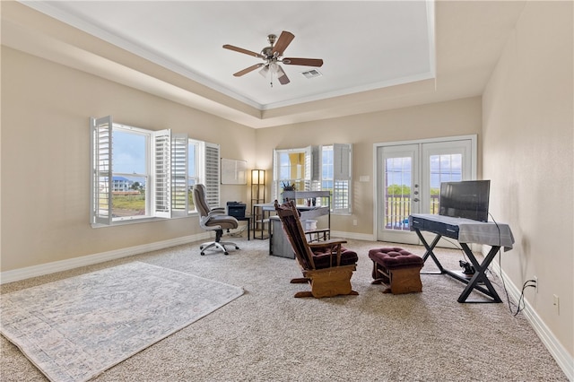 office area featuring a tray ceiling, ceiling fan, carpet, and a healthy amount of sunlight