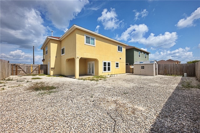 rear view of property featuring a storage unit