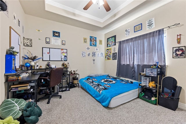 carpeted bedroom with ceiling fan, a tray ceiling, and ornamental molding