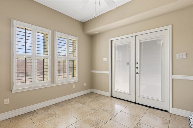 foyer entrance with ceiling fan and french doors