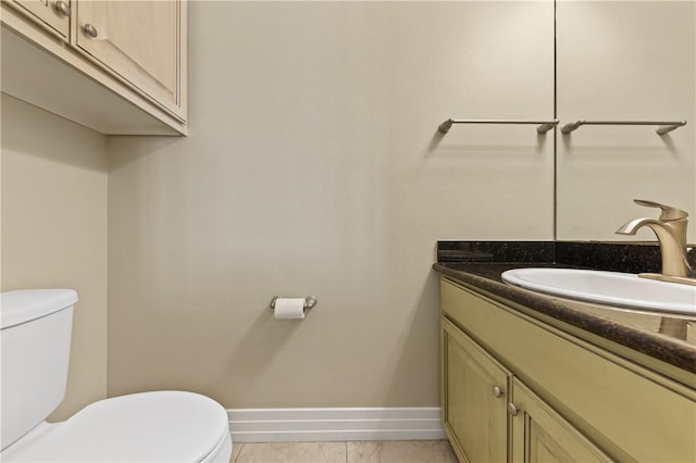 bathroom with toilet, vanity, and tile patterned floors