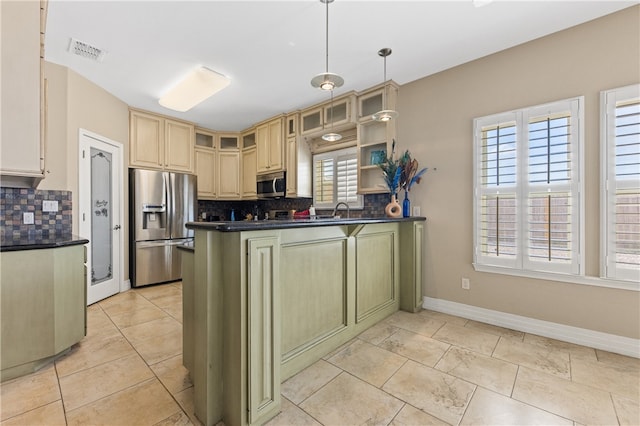 kitchen featuring kitchen peninsula, backsplash, hanging light fixtures, and stainless steel appliances