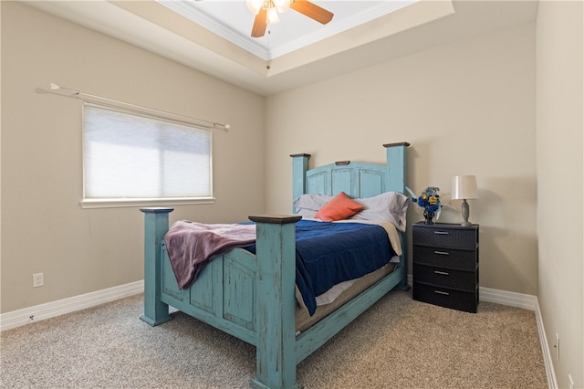 carpeted bedroom featuring ornamental molding, a tray ceiling, and ceiling fan