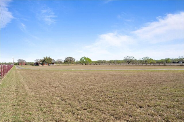 view of yard with a rural view and fence