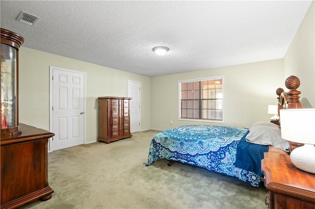 carpeted bedroom featuring visible vents and a textured ceiling