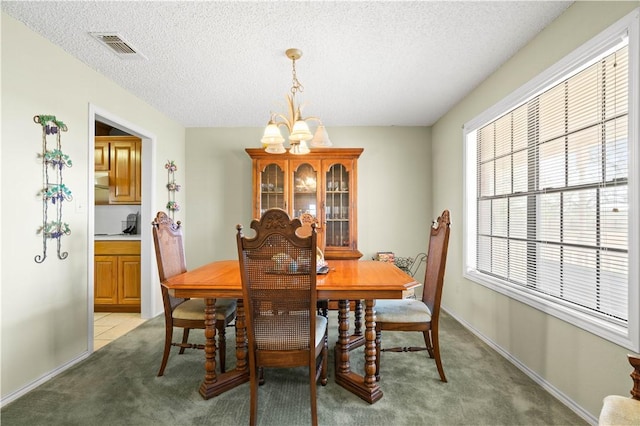 dining area with visible vents, baseboards, light colored carpet, and a textured ceiling