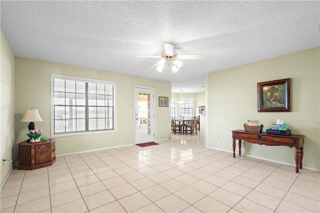 foyer featuring light tile patterned flooring, baseboards, a textured ceiling, and a ceiling fan