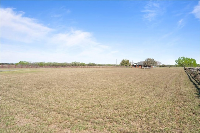 view of yard featuring a rural view and fence