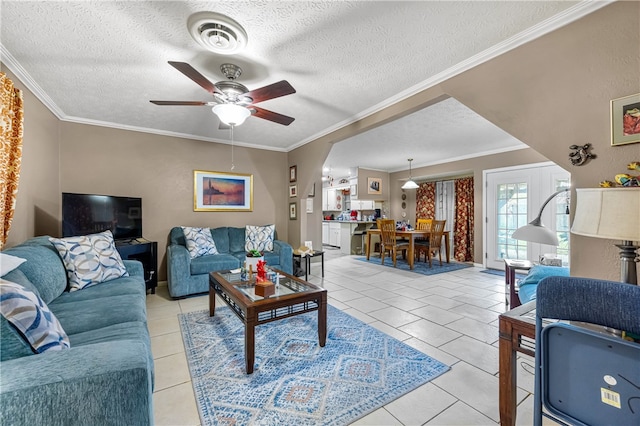 tiled living room with ornamental molding, a textured ceiling, and ceiling fan