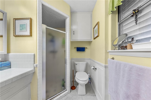 bathroom featuring walk in shower, tile patterned flooring, a textured ceiling, vanity, and toilet