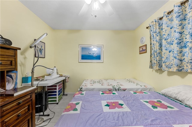 tiled bedroom featuring a textured ceiling and ceiling fan