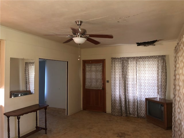 interior space with ceiling fan