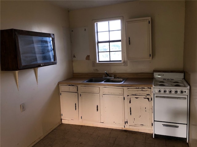 kitchen with white cabinets, white range, and sink