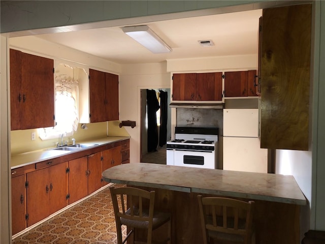 kitchen with decorative backsplash, white appliances, sink, and a kitchen bar