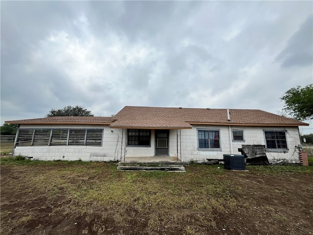 back of property with a lawn and cooling unit