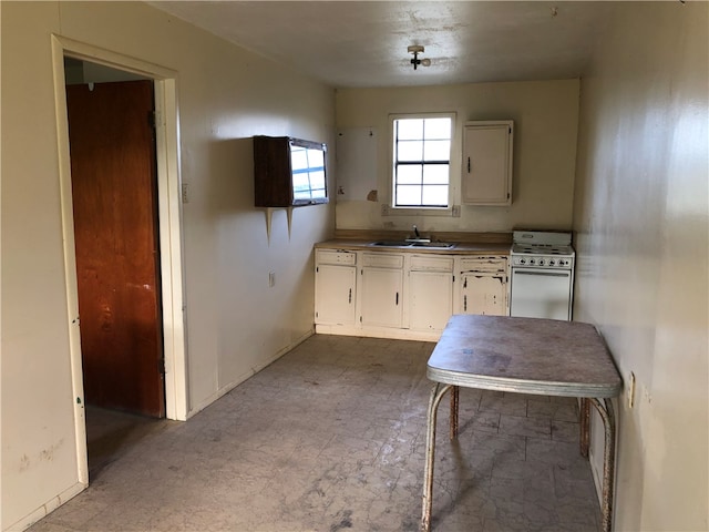 kitchen with white cabinetry, sink, and white range