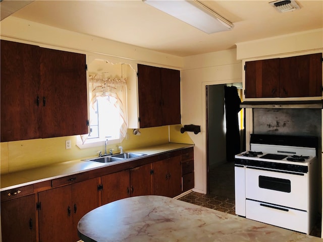 kitchen featuring white range oven and sink