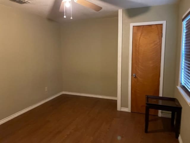 unfurnished room with dark hardwood / wood-style flooring and ceiling fan