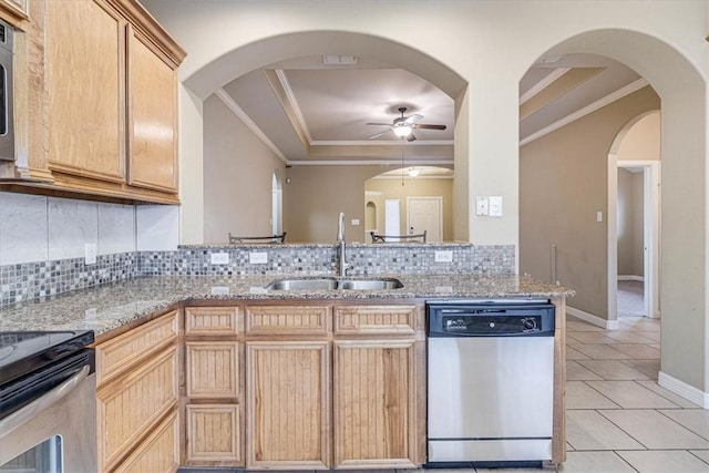 kitchen with light stone counters, sink, decorative backsplash, and appliances with stainless steel finishes