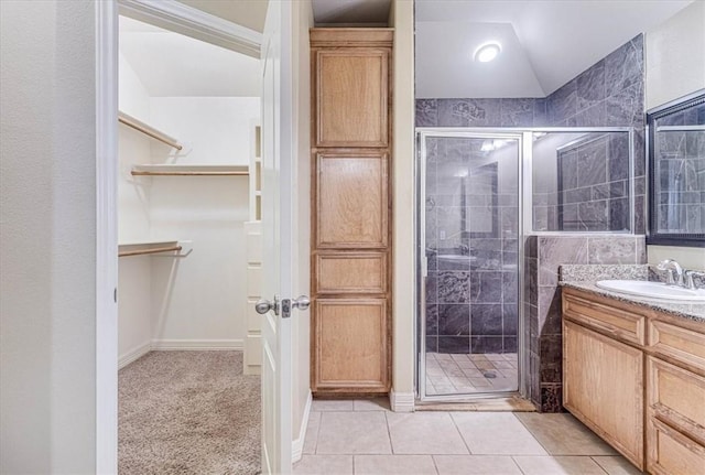 bathroom with vanity, an enclosed shower, vaulted ceiling, and tile patterned floors