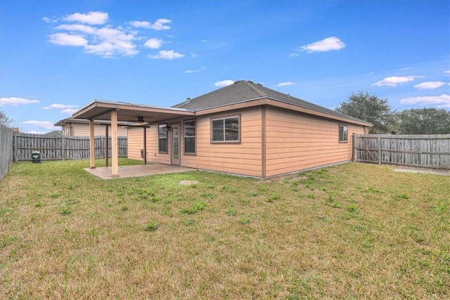 rear view of house featuring a lawn and a patio