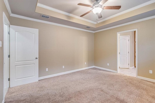 empty room with light carpet, crown molding, a raised ceiling, and ceiling fan