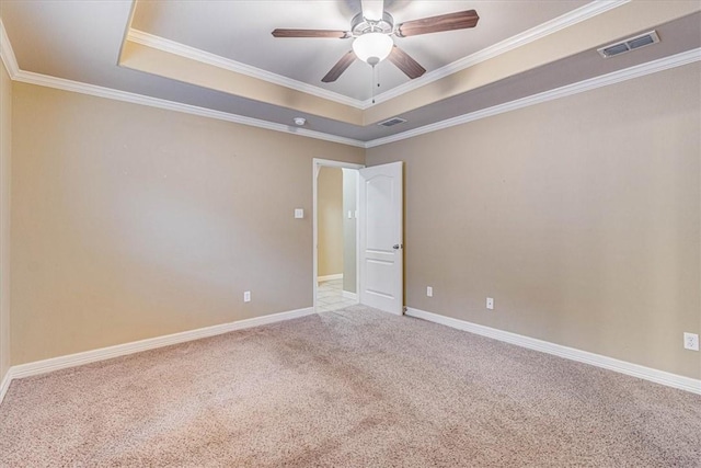 carpeted spare room featuring ceiling fan, ornamental molding, and a raised ceiling