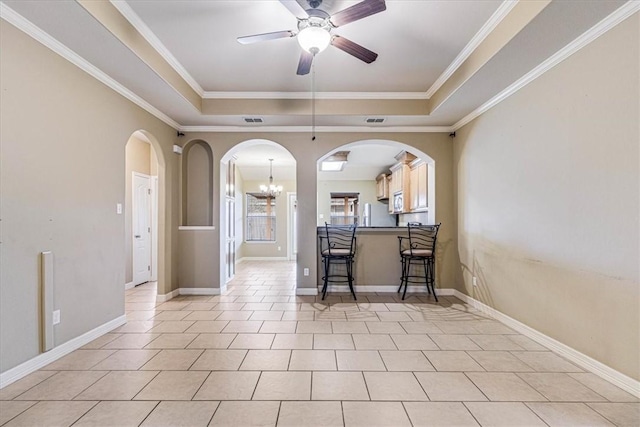 kitchen featuring crown molding, light tile patterned flooring, a raised ceiling, and ceiling fan with notable chandelier