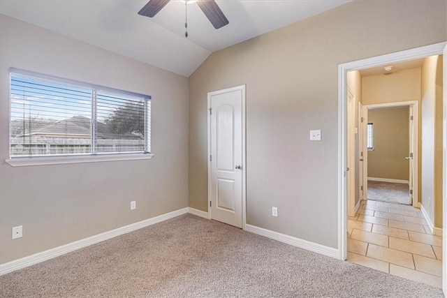 unfurnished bedroom with vaulted ceiling, light colored carpet, and ceiling fan