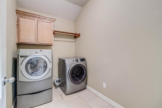 laundry area with cabinets, light tile patterned floors, and washing machine and clothes dryer