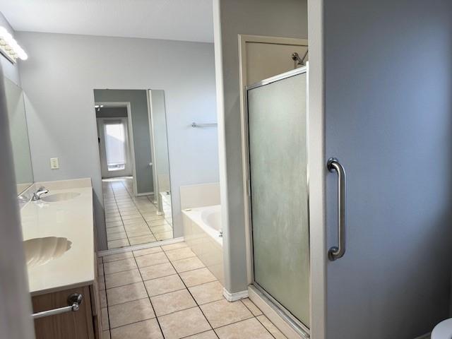 bathroom with tile patterned floors, vanity, and independent shower and bath