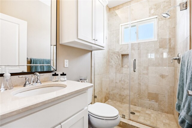 bathroom with an enclosed shower, vanity, and toilet