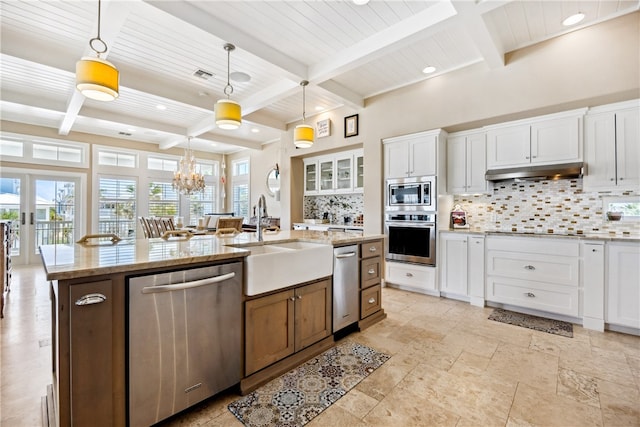 kitchen featuring pendant lighting, white cabinets, a center island with sink, and stainless steel appliances