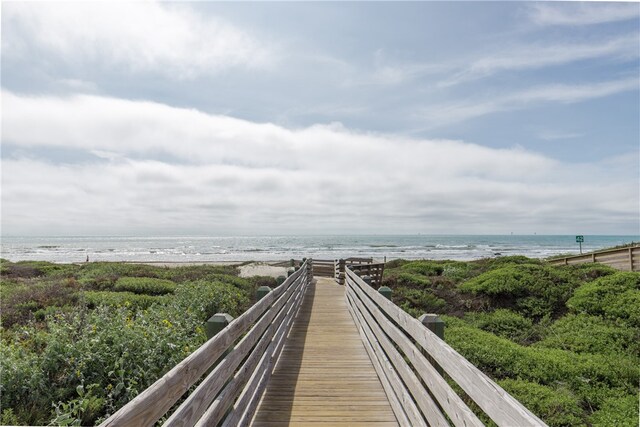 view of property's community with a water view and a beach view