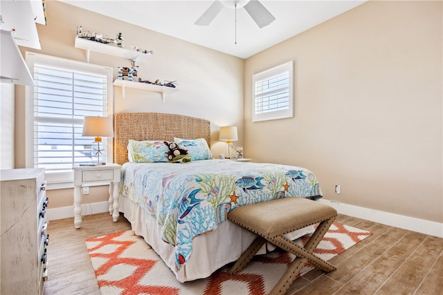 bedroom with light wood-type flooring, multiple windows, and ceiling fan