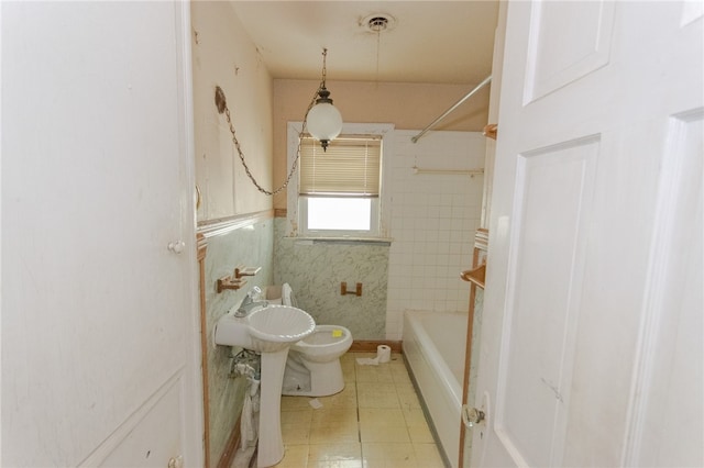 bathroom featuring tile patterned floors, shower / bathtub combination, tile walls, and toilet