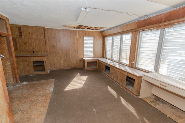 unfurnished living room with wood walls