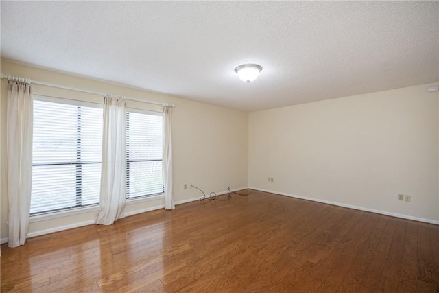 unfurnished room featuring wood-type flooring and a textured ceiling