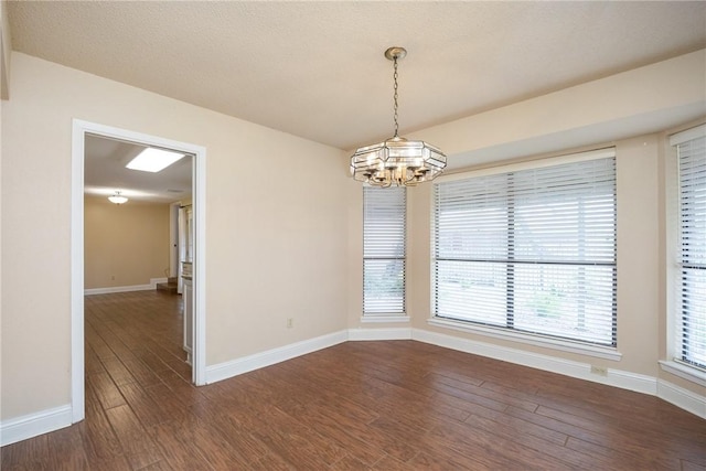 unfurnished room featuring dark wood-type flooring and a chandelier