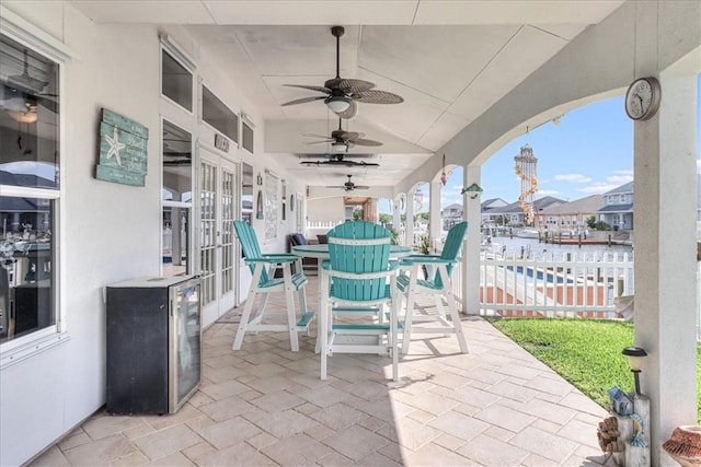 view of patio / terrace with ceiling fan and a water view