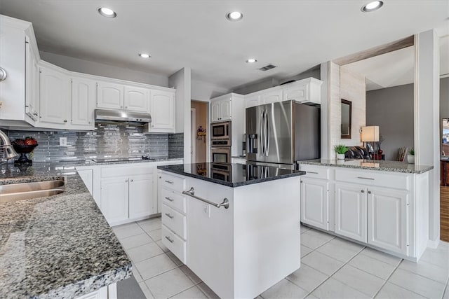 kitchen with a center island, sink, stainless steel appliances, tasteful backsplash, and white cabinets