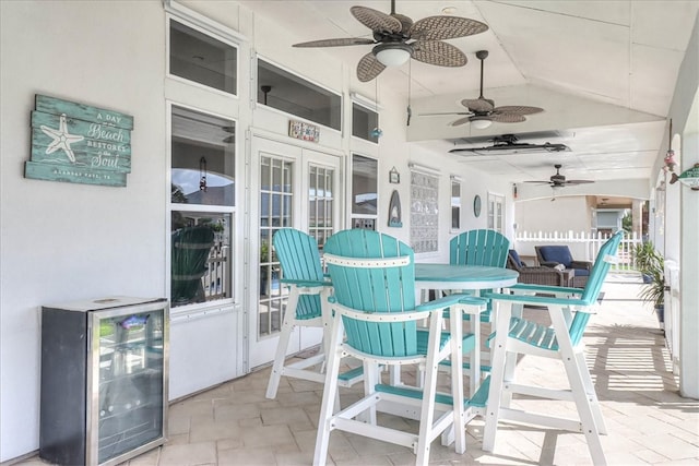 sunroom / solarium with ceiling fan, lofted ceiling, and wine cooler