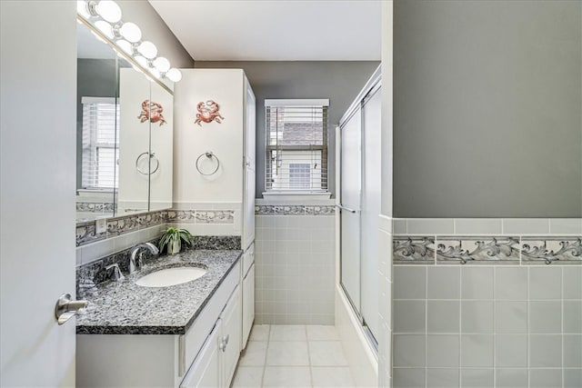 bathroom featuring tile patterned floors, plenty of natural light, vanity, and tile walls