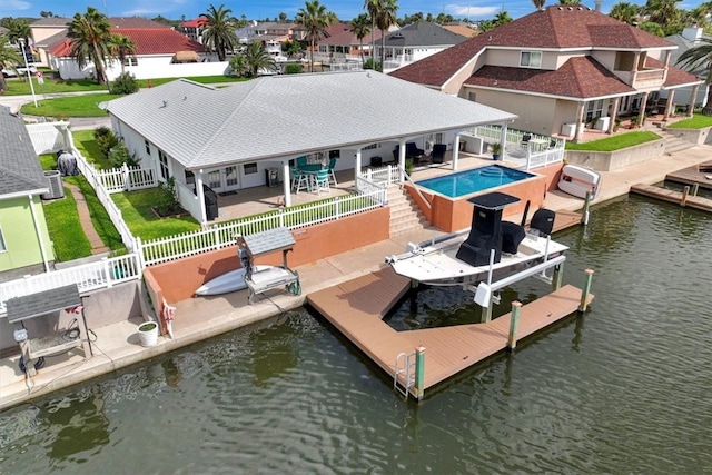 exterior space with central AC unit, a patio area, a water view, and a swimming pool