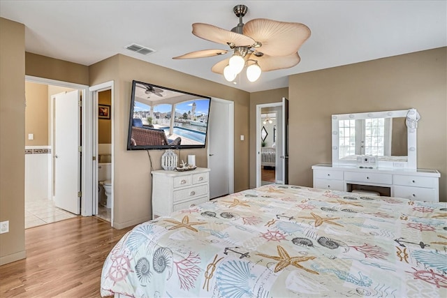 bedroom featuring connected bathroom, light hardwood / wood-style flooring, and ceiling fan