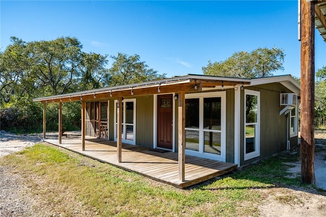 rear view of house featuring a lawn and a wall mounted air conditioner