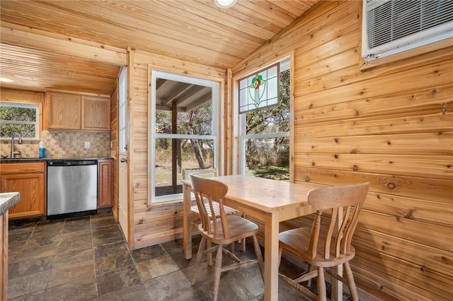 dining room featuring a wall unit AC, wood ceiling, wooden walls, and sink