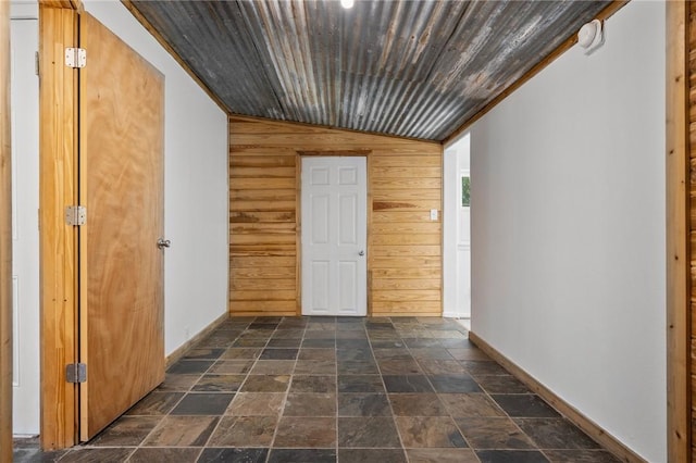 hall featuring lofted ceiling, wood ceiling, and wooden walls