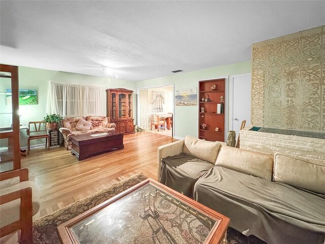 3434 Kay St, Corpus Christi, TX 78411 - living area with wood finished floors, baseboards, a textured ceiling, and built in shelves